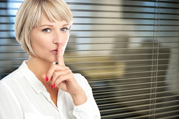 Young businesswoman finger on lips — Stock Photo, Image