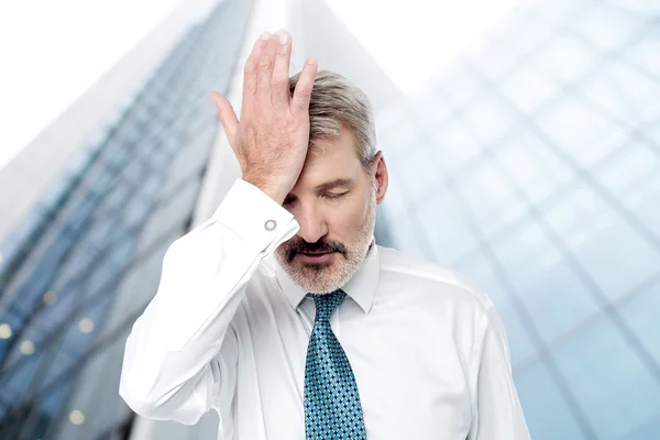 Geschäftsmann hält die Hand auf der Stirn — Stockfoto