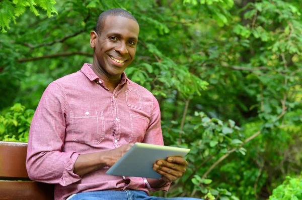 Chico feliz usando su PC tableta, al aire libre —  Fotos de Stock