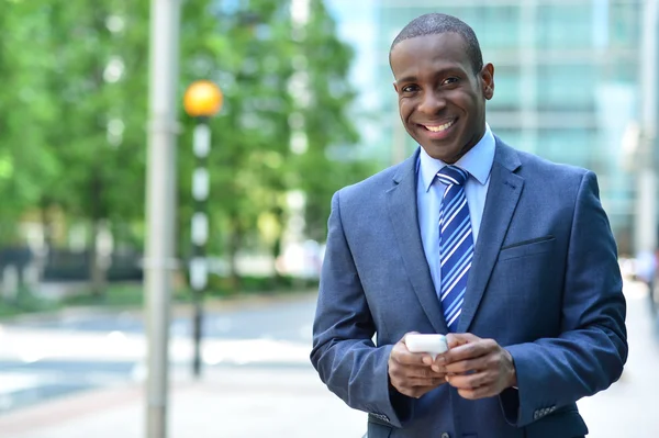 Hombre de negocios sonriente sosteniendo Smartphone —  Fotos de Stock