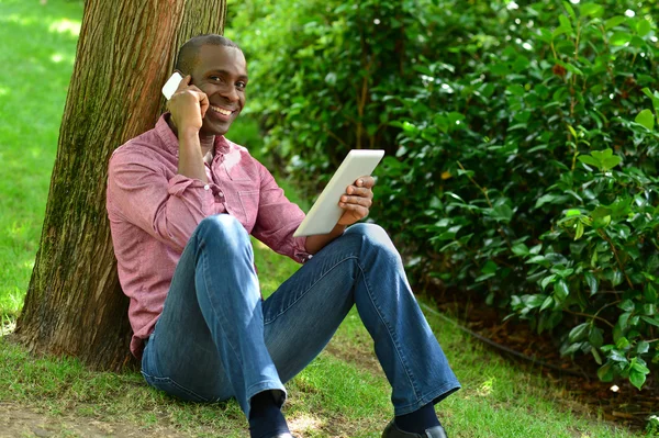 Hombre africano con teléfono inteligente y tableta — Foto de Stock