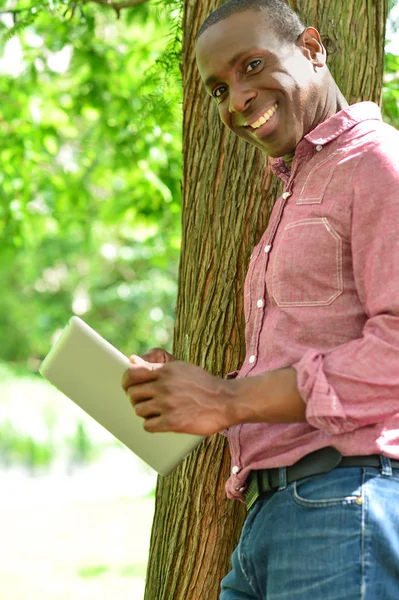 Rilassato uomo sorridente utilizzando il suo tablet digitale — Foto Stock