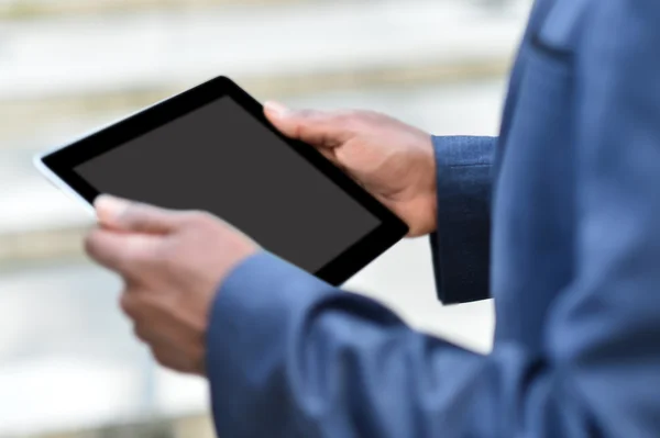 Бизнесмен держит планшет на открытом воздухе — стоковое фото