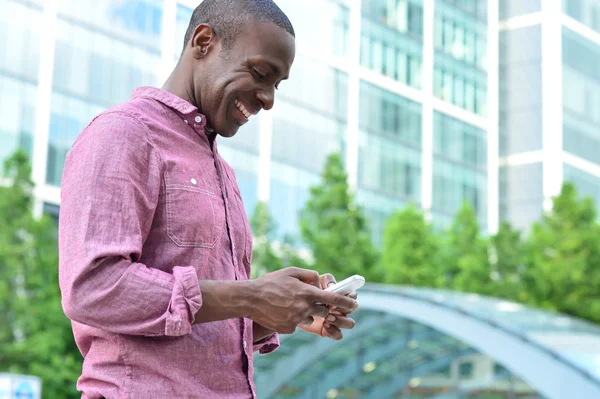 Usmívající se muž pomocí svého mobilního telefonu — Stock fotografie