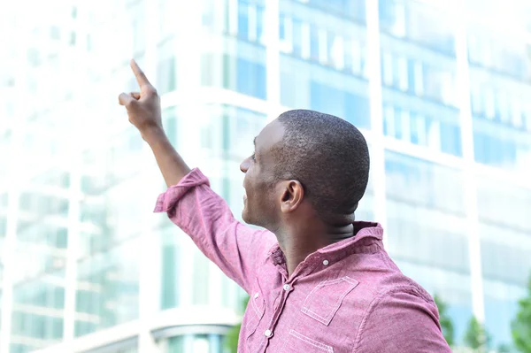 Hombre casual señalando con el dedo al edificio —  Fotos de Stock