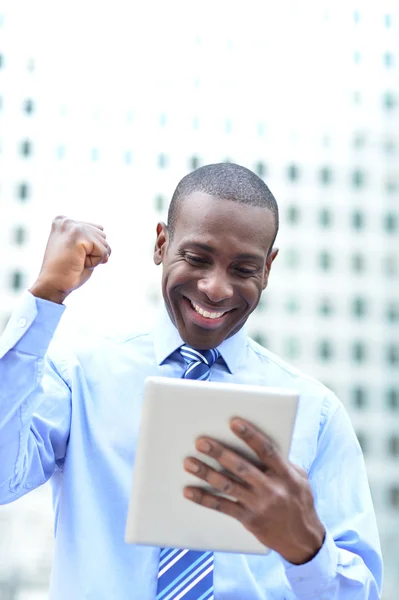 Executive celebrates his success holding a tablet — Stock Photo, Image