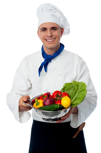 Chef holding colander with vegetables — Stock Photo, Image