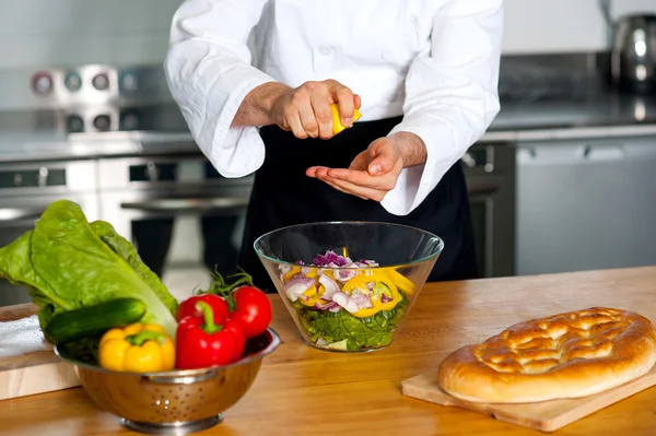 Männlicher Koch bereitet Gemüsesalat zu — Stockfoto