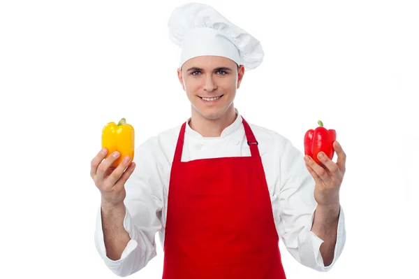 Chefe masculino mostrando capsicums — Fotografia de Stock