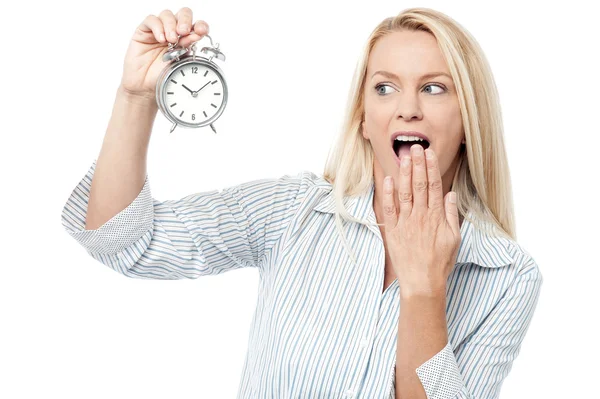 Shocked woman holding alarm clock — Stock Photo, Image