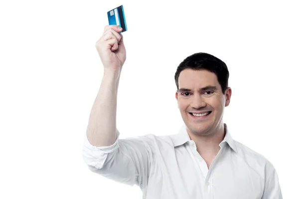 Χαμογελαστός άνθρωπος κρατά ψηλά την πιστωτική του κάρτα — Φωτογραφία Αρχείου