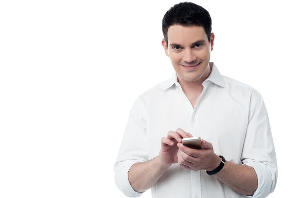Glimlachend slim gebruik van zijn mobiele telefoon — Stockfoto