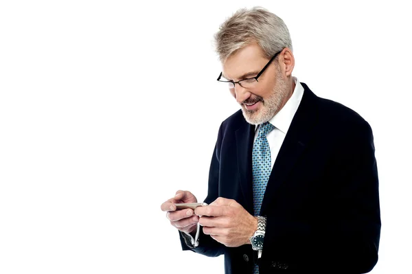 Senior Geschäftsmann SMS auf dem Handy — Stockfoto