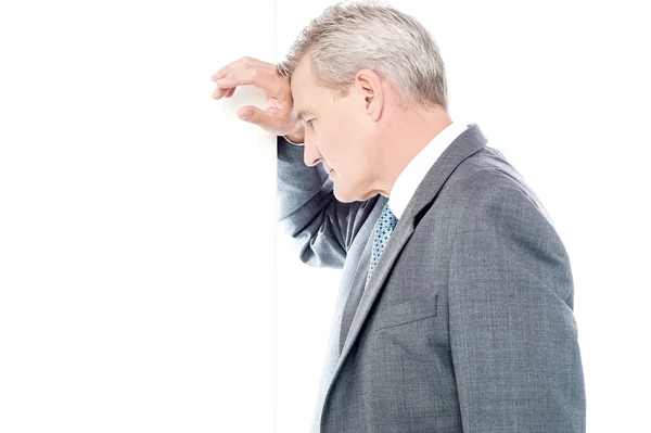 Businessman leaning head on wall — Stock Photo, Image