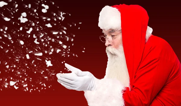 Santa claus blåser bort snö — Stockfoto