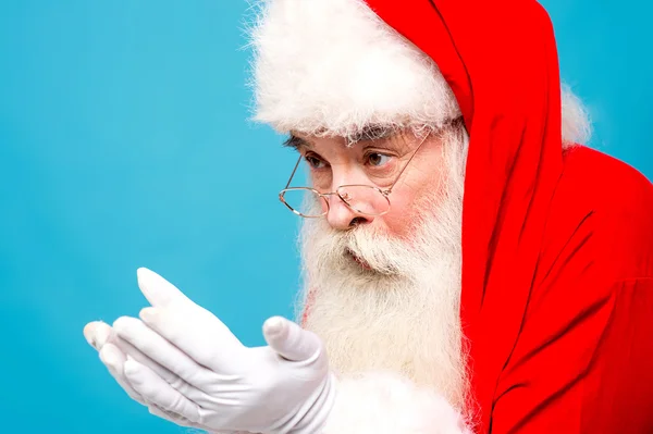 Weihnachtsmann schaut auf seine offenen Handflächen — Stockfoto