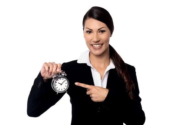 Businesswoman holding and pointing alarm clock — Stock Photo, Image