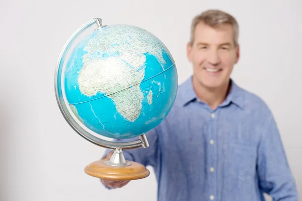 Hombre mostrando globo a cámara — Foto de Stock