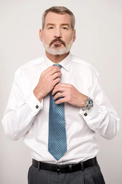 Male executive adjusting his neck tie — Stock Photo, Image