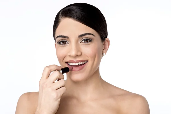 Mujer aplicando lápiz labial en los labios — Foto de Stock