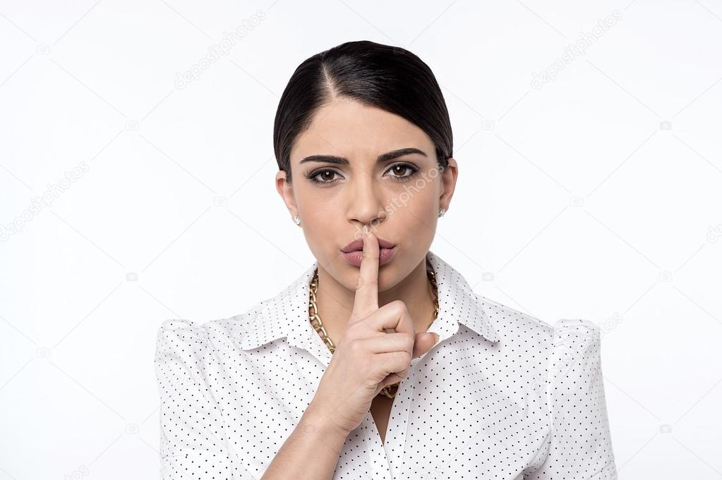 Woman keeping finger on lips
