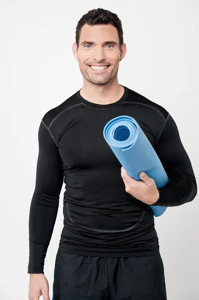 Fitness man håller träningsmatta — Stockfoto