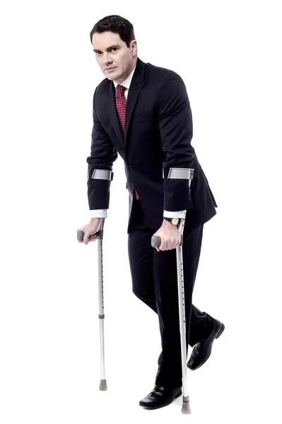 Businessman with crutches — Stock Photo, Image