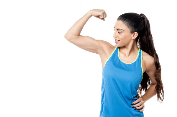 Žena při pohledu na její biceps — Stock fotografie