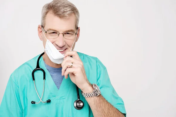 Médico masculino removendo sua máscara — Fotografia de Stock