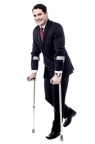Businessman walk with crutches — Stock Photo, Image