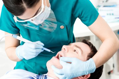 Diş asistanı erkek hasta tedavi