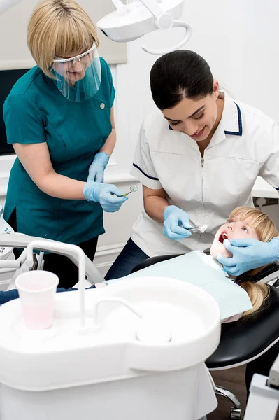 Dentistas que realizan un procedimiento dental — Foto de Stock