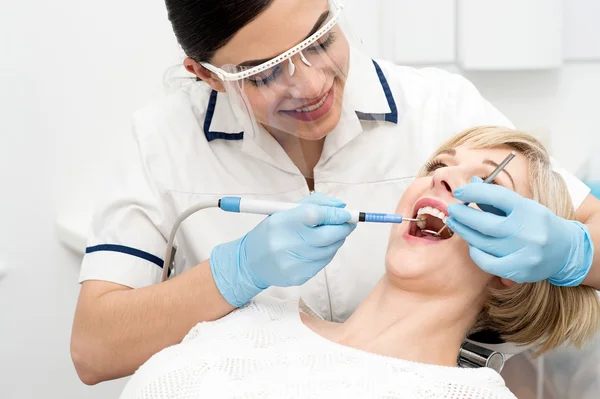 Dentista cura una donna denti — Foto Stock