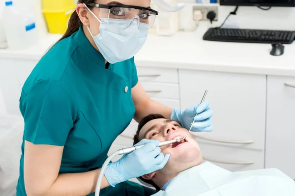 Tannlege som undersøker munnen på pasienten – stockfoto