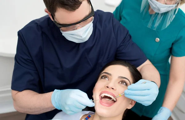 Dentista examinando la boca del paciente femenino — Foto de Stock