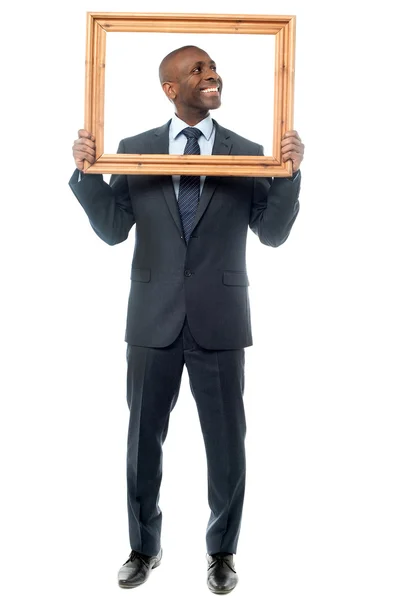 Businessman holding wooden picture frame — Stock Photo, Image