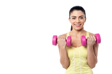 Dambıllarla egzersiz yapan kadın.