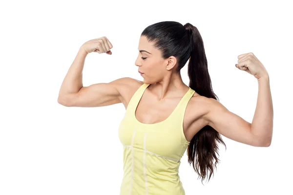 Žena při pohledu na její biceps — Stock fotografie