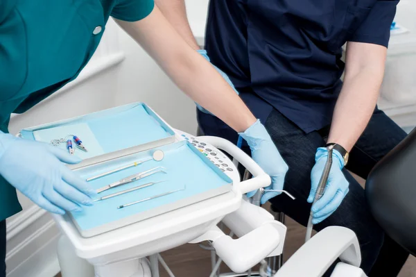 Стоматолог и ассистент с подносом для инструментов — стоковое фото