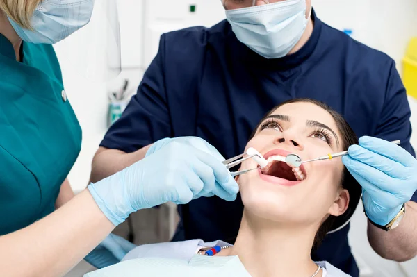 Dentiste traitant les dents des patients — Photo