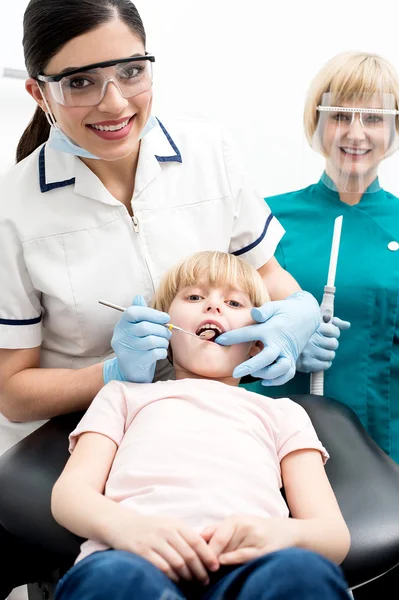 Dentiste et assistante examinant une petite fille — Photo