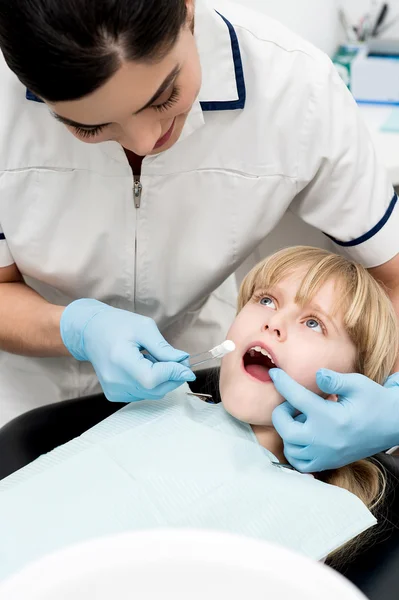 Assistente dentale esaminare una bambina — Foto Stock