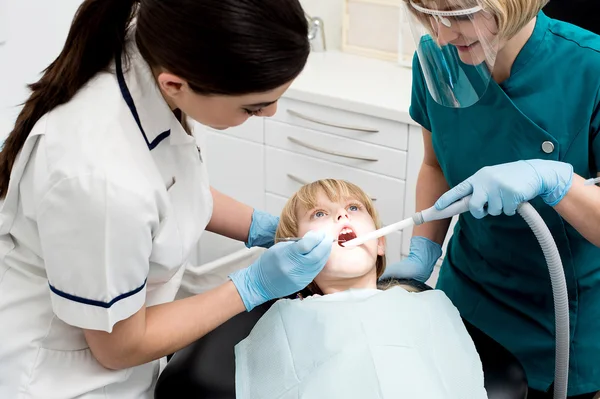 Dentist and nurse are curing patient — Stock Photo, Image