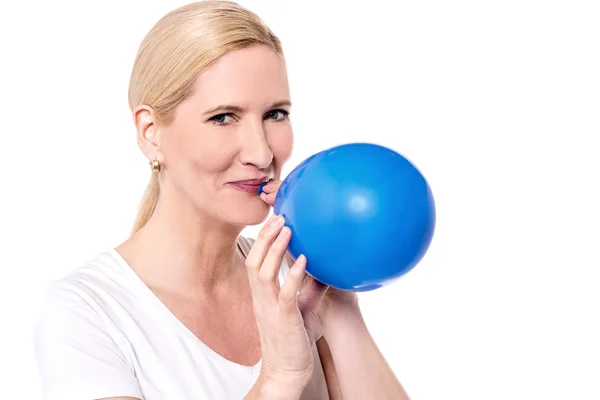 Mujer soplando un globo azul — Foto de Stock