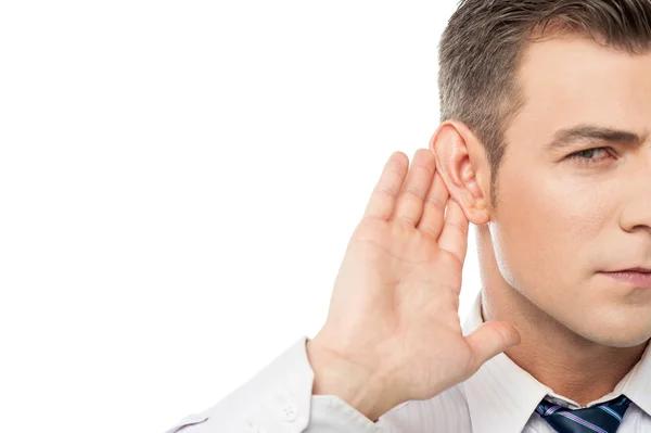 Businessman holds his hand near ear — Stock Photo, Image