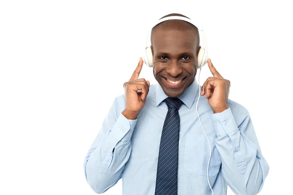 Executivo masculino desfrutando de músicas com fones de ouvido — Fotografia de Stock