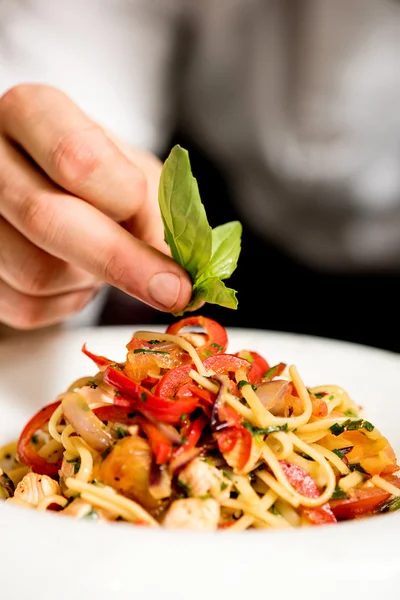 Kocken hand decorating pastasallad — Stockfoto