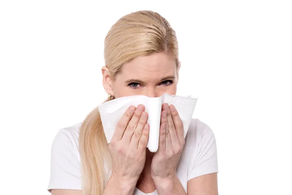 Kranke Frau pustet sich die Nase aus — Stockfoto