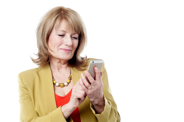 Зрелая женщина набирает номер на смартфоне — стоковое фото