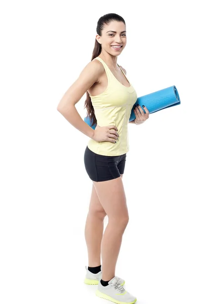 Mulher com tapete de exercício enrolado — Fotografia de Stock
